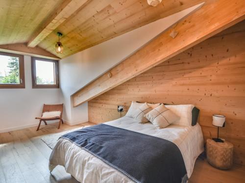 une chambre avec un lit dans une pièce avec des plafonds en bois dans l'établissement Appartement T3 Neuf aux Gets - Près des Pistes, 2 Parkings + Box, Linge Inclus - FR-1-685-71, aux Gets