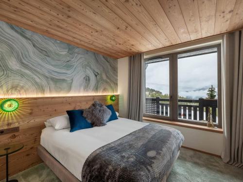 une chambre avec un lit et une grande fenêtre dans l'établissement Luxueux Appartement Neuf à Courchevel 1850 - Ski-in/Ski-out, Piscine, Spa, 3 Chambres + Coin Montagne - FR-1-564-110, à Courchevel