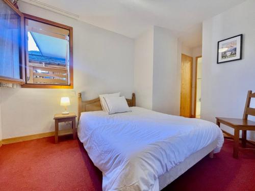 a bedroom with a white bed and a window at Charmant duplex 6 pers au cœur du village avec piscine et parking - FR-1-505-192 in Notre-Dame-de-Bellecombe