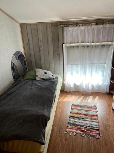 a bedroom with a bed with a fan and a rug at Mieszkanie Strajku Dokerów 2 lok 5 in Gdańsk