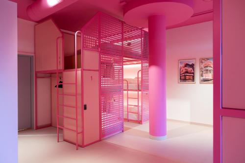 奧斯陸的住宿－Bunks at Rode，一间设有粉红色双层床和柱子的房间
