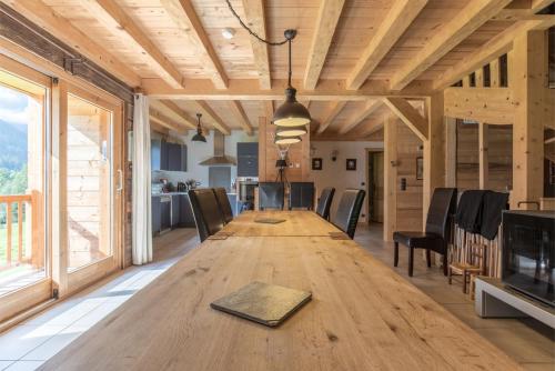une grande table en bois dans une pièce avec des chaises dans l'établissement Chalet Evasion, à Hauteluce
