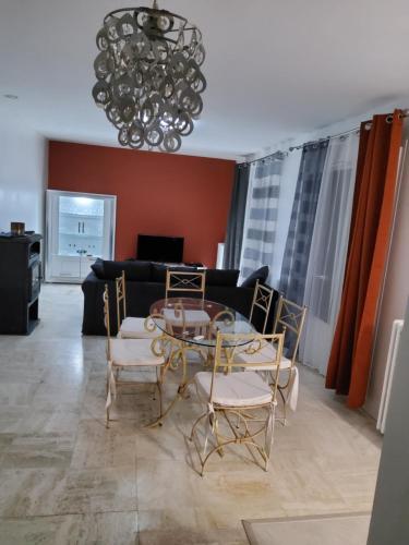 un salon avec un canapé, une table et des chaises dans l'établissement Residom, à Bondoufle