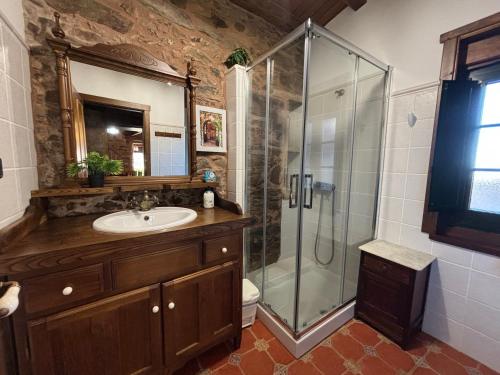 ein Bad mit einer Glasdusche und einem Waschbecken in der Unterkunft Eira de Bergondo in Bergondo