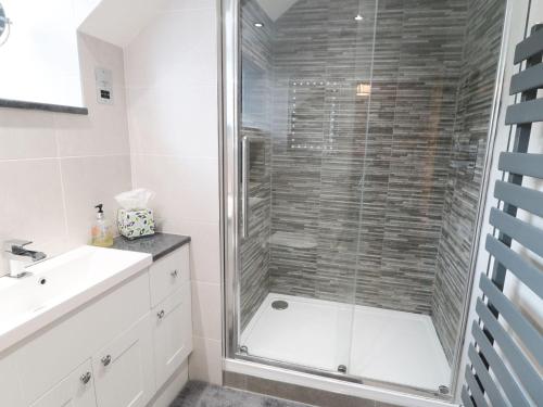 ein Badezimmer mit einer Glasdusche mit Waschbecken in der Unterkunft Buttercup Cottage in Castleton