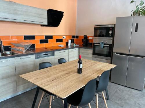 - une bouteille de vin assise sur une table en bois dans la cuisine dans l'établissement Magnifique appartement moderne hyper centre, à Saint-Étienne