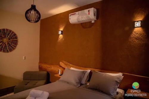 um quarto com uma cama e ar condicionado na parede em Espaco Morro do Frota em Pirenópolis