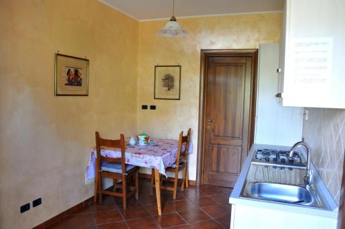eine Küche mit einem Tisch und eine Küche mit einem Waschbecken in der Unterkunft B&B Colle Mattia in Colonna