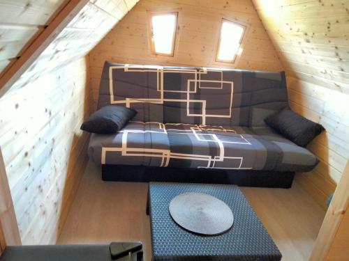 a loft bed in a tiny house with a table at Cabane - La Forest in Épuisay