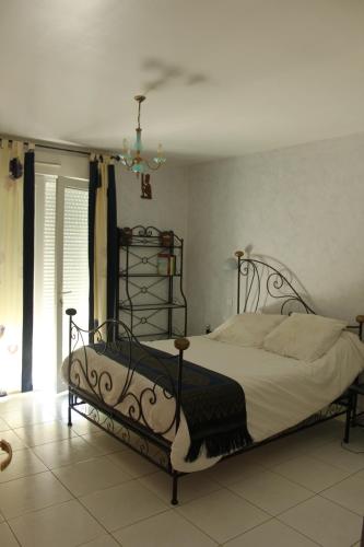 - une chambre dotée d'un lit avec un cadre en fer forgé dans l'établissement maison dans un charmant village au cœur des garrigues, à Sainte-Croix-de-Quintillargues