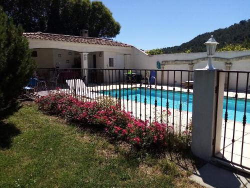 une clôture fleurie à côté d'une piscine dans l'établissement maison dans un charmant village au cœur des garrigues, à Sainte-Croix-de-Quintillargues