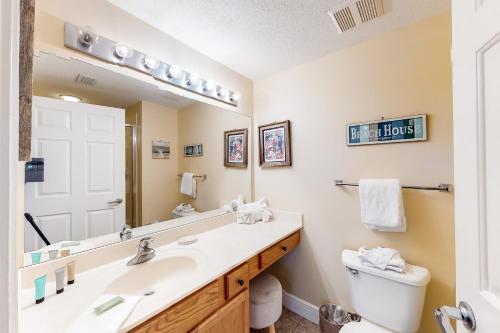 a bathroom with a sink and a mirror and a toilet at Waters Edge Condominiums in Fort Walton Beach