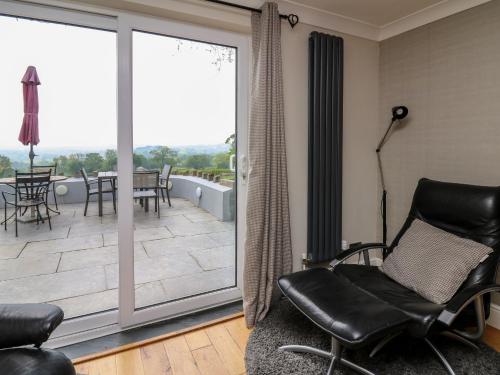 a living room with chairs and a sliding glass door at Aberdauddwr in Llanwnen