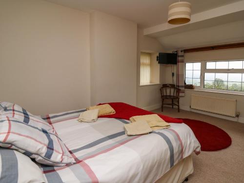 1 dormitorio con 2 camas y toallas. en Aberdauddwr en Llanwnen