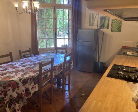 a kitchen with a table and a kitchen with a refrigerator at Gite Carlit in Prades