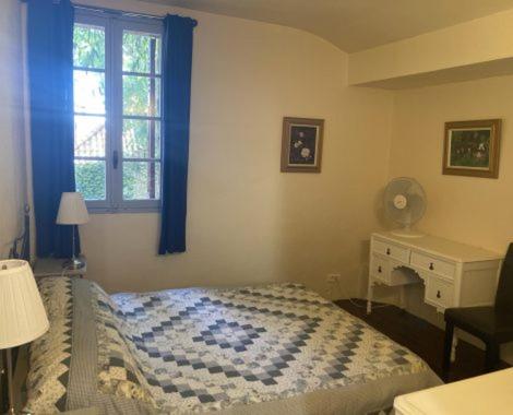 a bedroom with a bed and a desk and a window at Gite Carlit in Prades