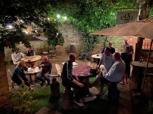 a group of people sitting at tables in a garden at Vivians rooftop apartments in Castle Donington