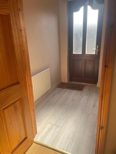 an empty room with a door and a wooden floor at The perfect rest place in Omagh