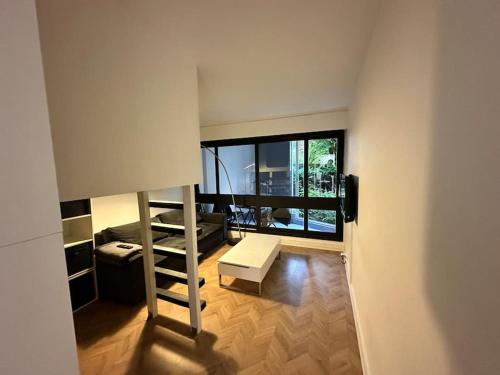 une petite chambre avec un lit mezzanine et un salon dans l'établissement Studio luxueux avec PISCINE, à Le Chesnay