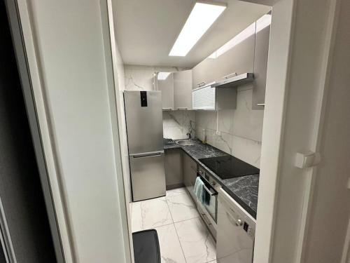 - une petite cuisine avec des armoires et des appareils blancs dans l'établissement Studio luxueux avec PISCINE, à Le Chesnay