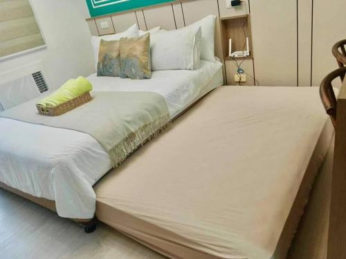 a couple of beds sitting next to each other at Casa Verde Studio at Azure North in San Fernando