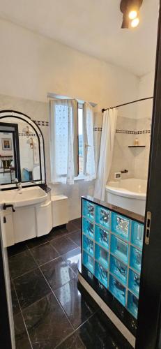 un baño con lavabo y bañera y lavabo y espejo en Casa Orchidea a La Spezia, en La Spezia