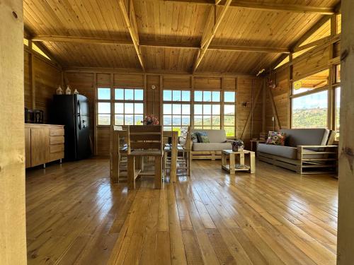 a kitchen and living room with a table and chairs at KUYAY in Ráquira