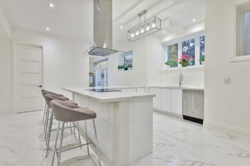 a white kitchen with stools at a counter at Comfortable Room in Toronto next to Yorkdale mall in Toronto