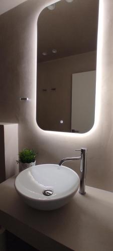 a bathroom with a white sink and a mirror at Elena Seafront Luxury Apartments in Almirida