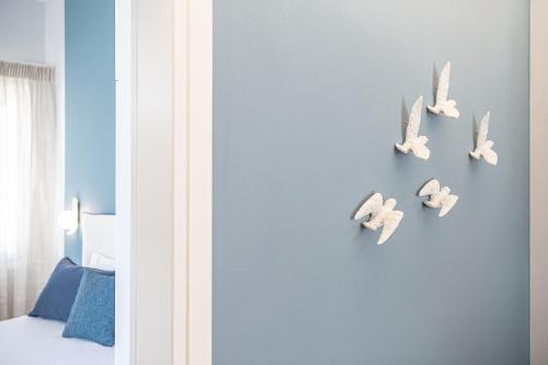 a bedroom with birds on a blue wall at Elena Seafront Luxury Apartments in Almirida