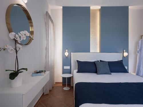 アルミリダにあるElena Apartmentsのベッドルーム1室(青い壁のベッド1台、鏡付)