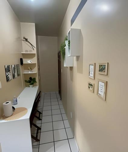 a kitchen with white cabinets and a white tile floor at Umbelino Moradia in Santarém