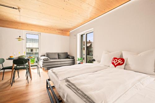 a bedroom with a large bed and a dining room at Einzimmer Wohlfühlapartment DREI klimatisiert in Friedrichshafen
