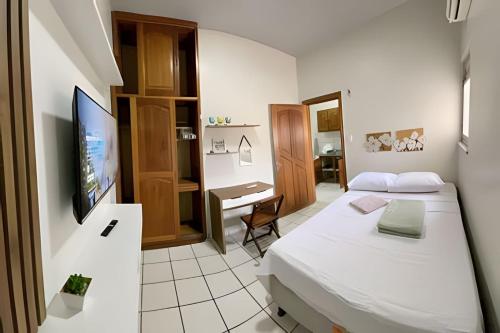 a bedroom with a bed and a desk and a television at Umbelino Moradia in Santarém
