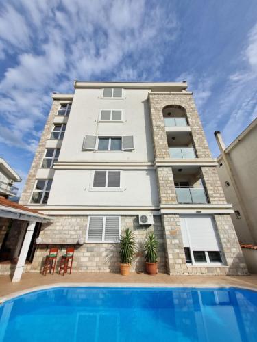 an apartment building with a pool in front of it at Mila & Aleksandr Apartments in Budva