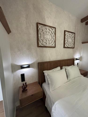 スキアトスタウンにあるThe MITS luxury apartmentsのベッドルーム1室(ベッド1台付)が備わります。壁に2枚の写真が飾られています。