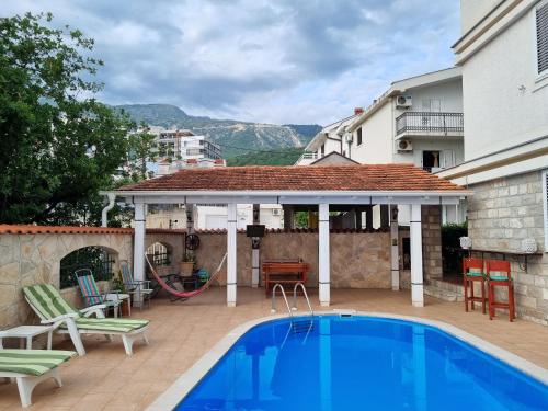 a swimming pool in front of a house at Mila & Aleksandr Apartments in Budva