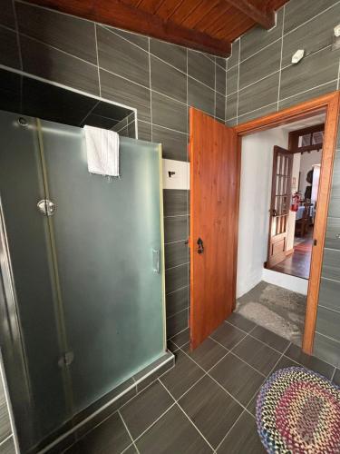 a bathroom with a shower and a glass door at Casa da Madrinha Graciosa in Trás dos Pomares