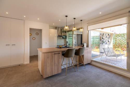 une cuisine avec un îlot et des tabourets de bar dans l'établissement LE SELI, Luxueux 2 pièces, centre d'Antibes, à Antibes