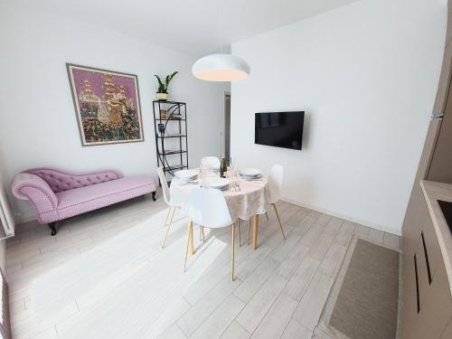 a living room with a table and a pink couch at HERON Apartment in Scardovari