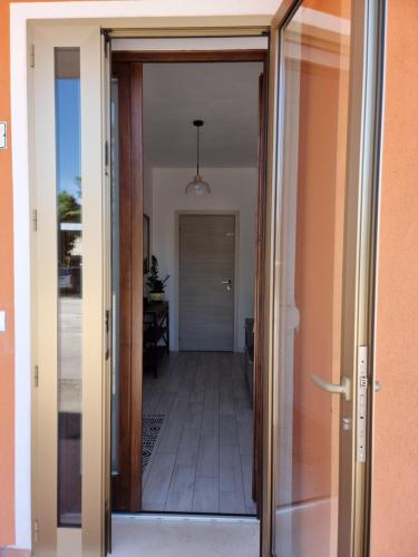 an open door of a room with a hallway at HERON Apartment in Scardovari