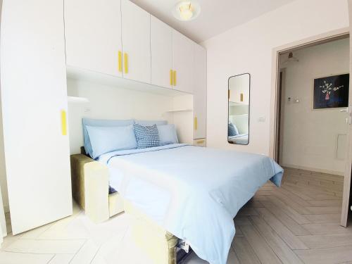 a white bedroom with a bed and a mirror at HERON Apartment in Scardovari