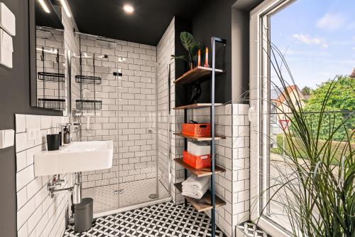 a white bathroom with a sink and a window at Einzimmer Wohlfühlapartment DREI klimatisiert in Friedrichshafen