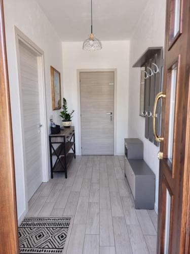a hallway with a door and a table and a floor at HERON Apartment in Scardovari