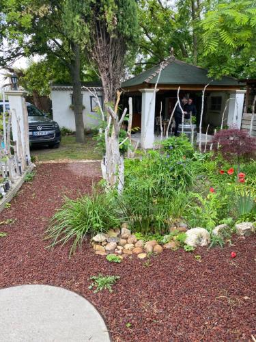 un jardin avec des plantes et des rochers devant une maison dans l'établissement Maison Sainte Geneviève, à Pernes-les-Fontaines