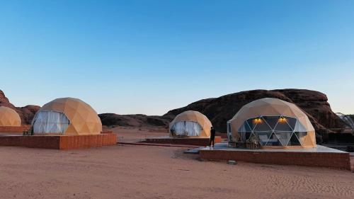 a group of domes in the desert at dusk at wadi rum fox road camp & jeep tour in Wadi Rum