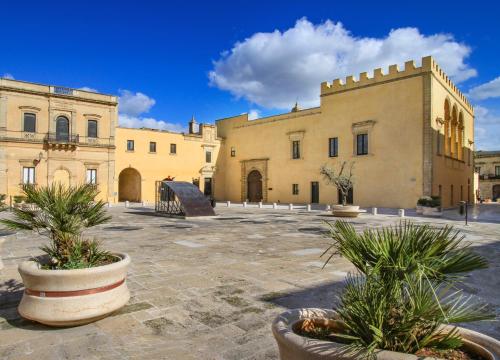 a building with two potted plants in a courtyard at Suite del Borgo in Presicce