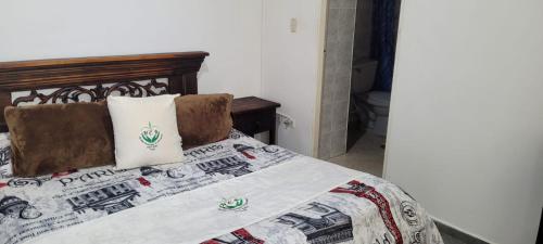 a bedroom with a bed with a train quilt at Hotel Colonial El Bosque in Tunja