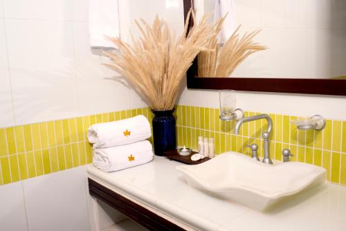 baño con lavabo y jarrón con toallas en Hotel Camoruco, en Yopal