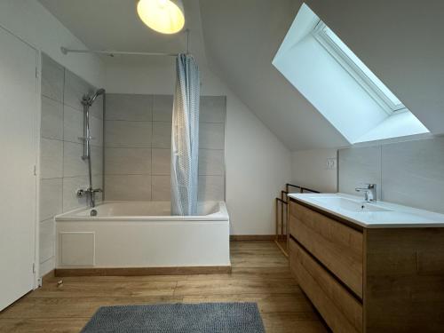 une salle de bain avec une baignoire, un lavabo et une fenêtre dans l'établissement La Pâquerie - Gite - Campagne - 12 pers - Rêve au Mans, à Saint-Vincent-du-Lorouër